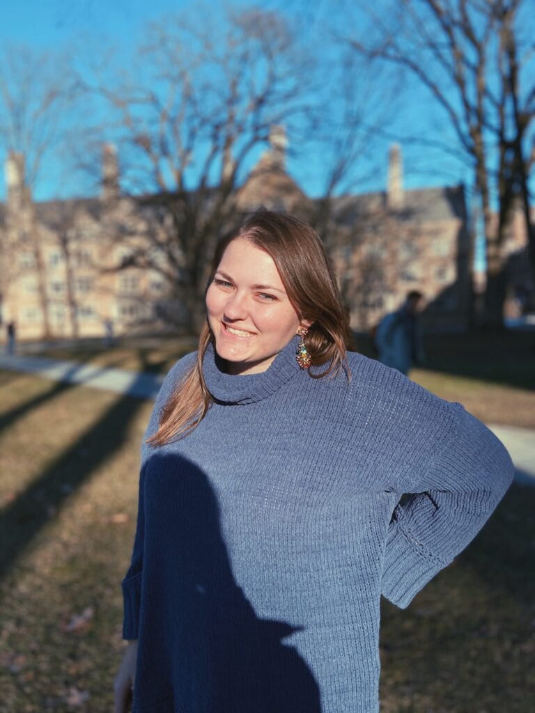 photo of Kara standing outside in a blue sweater