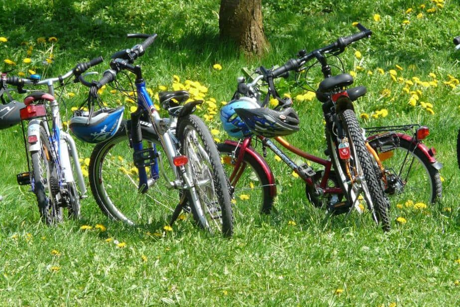 line of four bikes in grass with helmets on the handel bars
